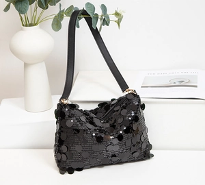 Détail de paillettes noires scintillantes sur le sac sous le bras à texture métallique