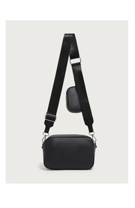 Close-up of black quilted camera bag with adjustable wide strap and small coin purse