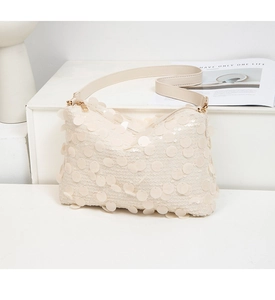 Détails de grands sequins beiges et fermeture éclair dorée sur un sac à bandoulière chic