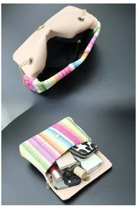 Detail view of rainbow straw woven bag interior showing storage for phone and essentials