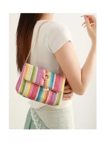 Close-up of colorful rainbow woven crossbody bag with gold chain and pearl pendant