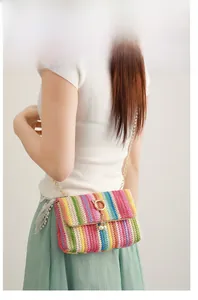 Detail of colorful rainbow woven crossbody bag with gold cat-ear lock and pearl charm