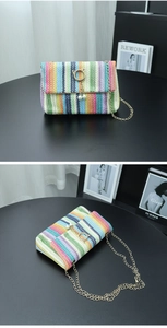 Detail of colorful woven crossbody bag with golden chain and pearl ring buckle