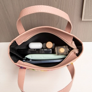 Pink handle straw tote bag showing internal storage capacity for daily essentials