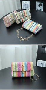 Close-up of a colorful striped woven straw bag with gold cat buckle and pearl charm