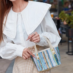 Fashionable woven tote bag with colorful stripes and white leather handles