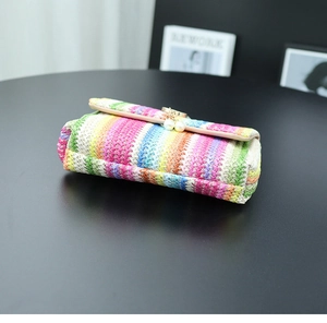 Detail of colorful woven straw bag with pearl pendants and elegant leather piping trim