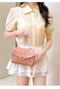 Detailed embroidery of pink flowers on small square bag with pearl handle for women