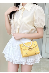 Floral embroidery small square bag with pearl handle worn by model on shoulder