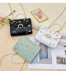 Detailed embroidery and pearl handle design on floral mini flap crossbody bags