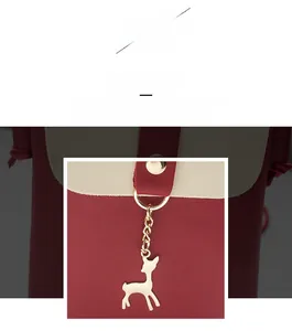 Close-up of contrast faux leather phone bag with gold deer charm and stud details