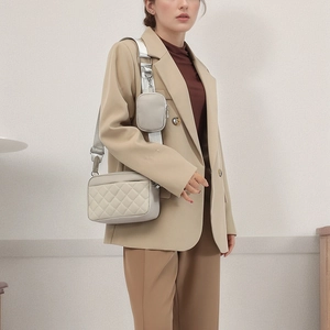 Quilted light gray crossbody bag with round pouch on wide strap and silver zippers