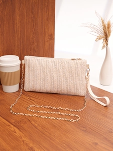 Close-up of woven square bag texture with gold chain on wooden surface decoration