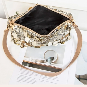 Sac sous les aisselles chic avec paillettes dorées et bandoulière kaki sur table