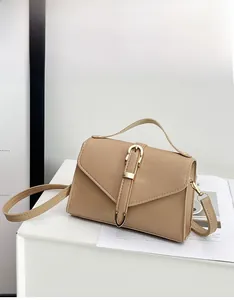 Detail of khaki square crossbody bag with metallic strap and elegant gold hardware