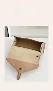 Detail view of the multi-layer interior and magnetic closure of the beige crossbody bag