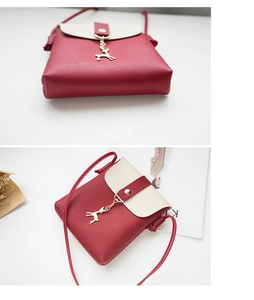 Close-up of red and white crossbody bag featuring premium leather texture and deer charm