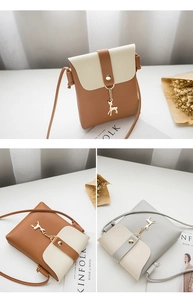 Detail of mini crossbody phone bag with metal deer charm and contrast color stitching