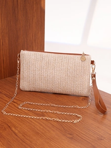 Detail of V-shaped woven texture on beige square bag with gold chain and brown strap