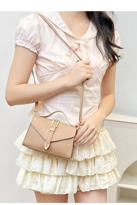 Camel small crossbody bag shown with adjustable strap and metallic buckle closure