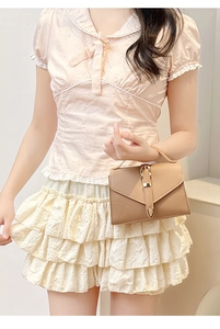 Detail of dark apricot crossbody bag with metal buckle on a stylish female model