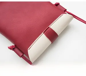 Close-up of color-block crossbody bag with red and beige texture and knotted strap