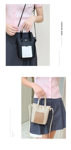 Detail of mini bucket bag showing dual handles and adjustable shoulder strap in two colors