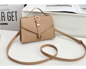Detailed view of beige envelope bag with golden buckle and textured synthetic leather