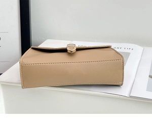 Detailed shot of the refined stitching and golden U-shaped buckle on a khaki crossbody bag