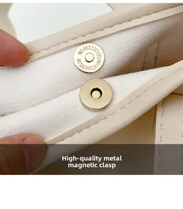 Detail of high-quality golden hardware magnetic buckle on creamy white leather handbag