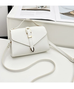 Detail of white PU leather crossbody bag with gold metal buckle and triangle flap