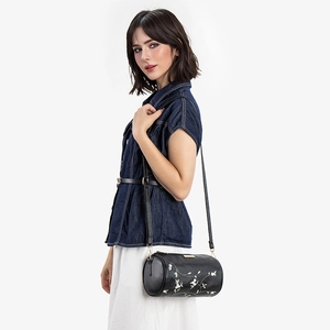 Sac cylindre noir élégant avec broderie florale et détails dorés porté par un mannequin