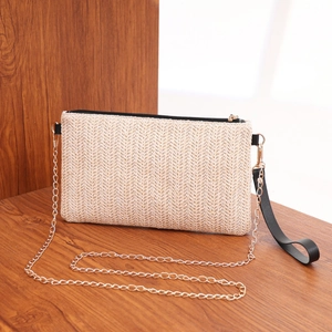 Minimalist woven straw crossbody bag with gold chain strap and black leather wristlet