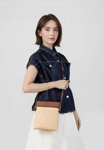 Detail of straw weave and brown leather patchwork crossbody bag with gold zipper