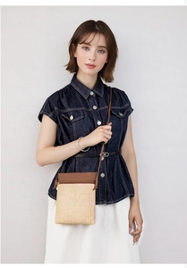 Detail of woven straw and dark brown PU leather patchwork on a small crossbody phone bag