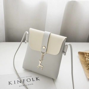 Chic two-tone phone crossbody bag with gold deer pendant on a white studio surface