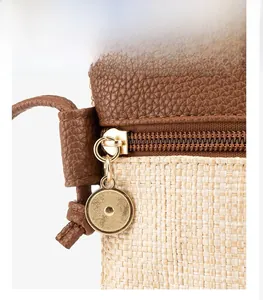 Detail of lychee pattern leather and straw woven texture with golden matte zipper hardware