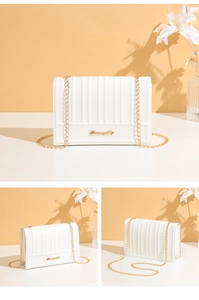 Détail d'un sac à bandoulière blanc plissé avec chaîne dorée et logo métallique
