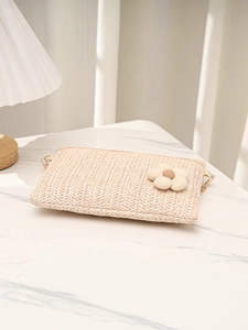 Détail de la pochette en paille tressée avec fleur 3D et anneau en D doré chic
