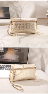 Detail of golden diamond-quilted PU leather handbag with dual zippers and chain strap