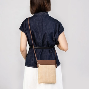Straw woven phone crossbody bag with brown leather patchwork and slim shoulder strap