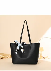 Detail der schwarzen Tote-Bag mit Lychee-Muster und dekorativem Seidenschal im Display
