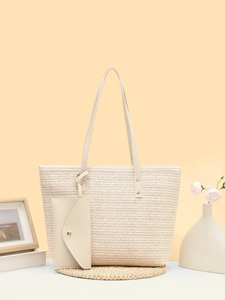 Detailed close-up of woven cream tote bag with leather straps and mini matching pouch