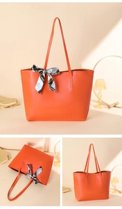 Detail der orangefarbenen Leder-Tote-Bag mit stilvollem gemustertem Seidenschal-Dekor