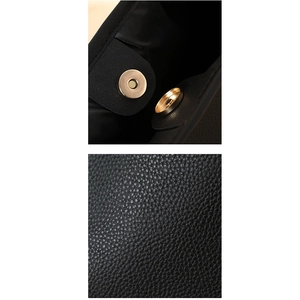 Detail der Litschi-Lederstruktur und goldener Magnetverschluss an der schwarzen Tragetasche