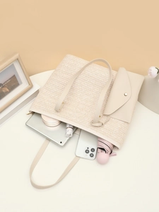 Spacious beige woven tote bag showing internal storage for tablets and cosmetics
