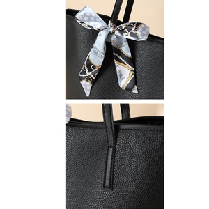 Detailansicht der schwarzen Lychee-Leder-Tote Bag mit Seidenschal und verstärkten Nähten