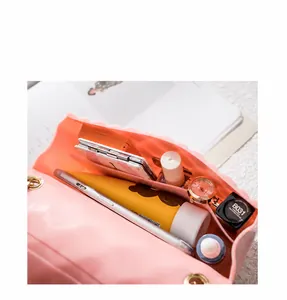 Internal view of pink jelly bag showing storage for phone, lipstick, and cosmetics