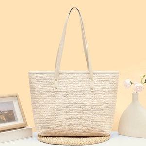 Minimalist beige woven tote bag with slim shoulder straps for summer beach leisure