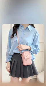 Detail of pink embossed mini shoulder bag with cat ear metal ring and pearl tassel charm